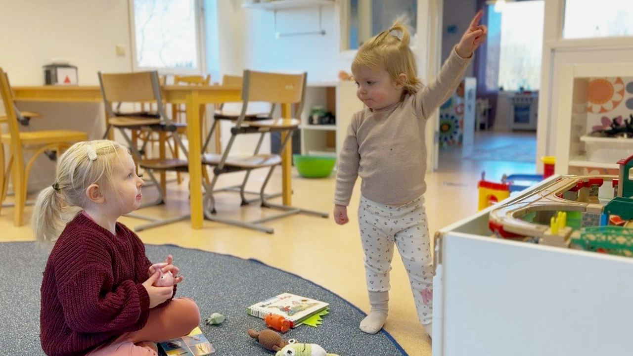 Två mindre barn i en förskolemiljö som tittar på varandra