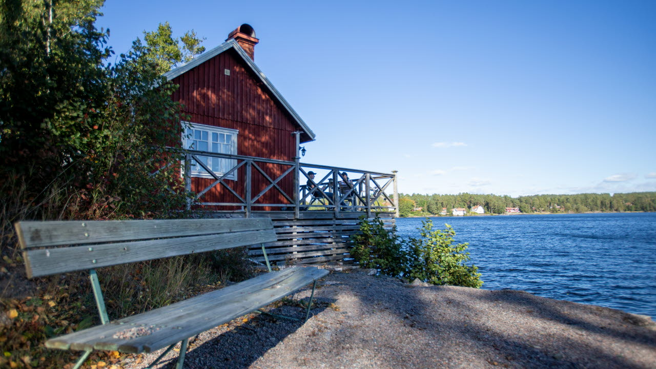 Röd stuga bredvid en strand