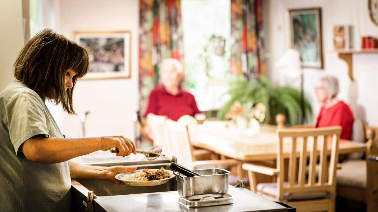 Vårdpersonal serverar middag