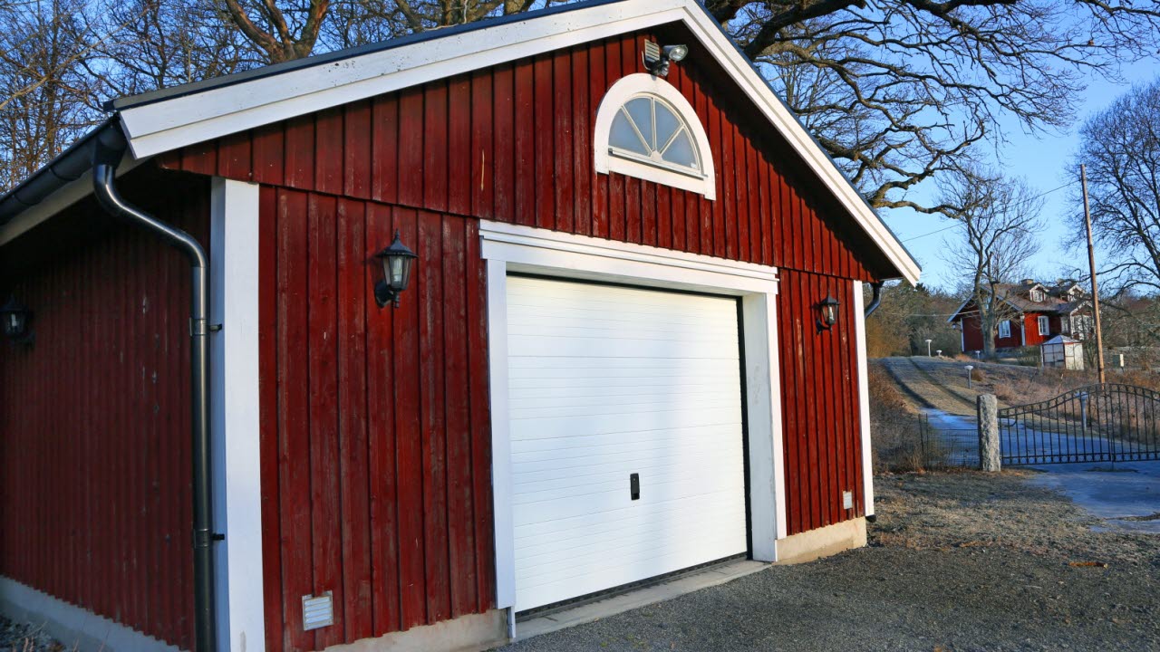 Ett rött garage med vit port
