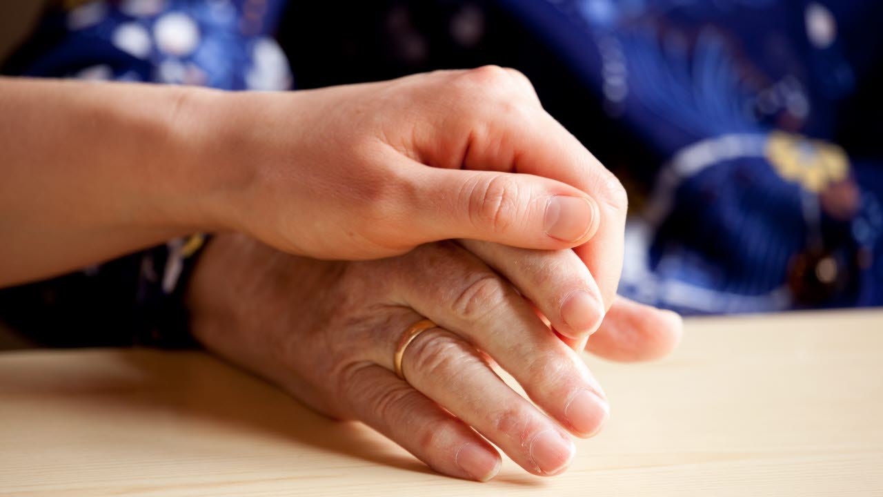 Ung och äldre håller hand.