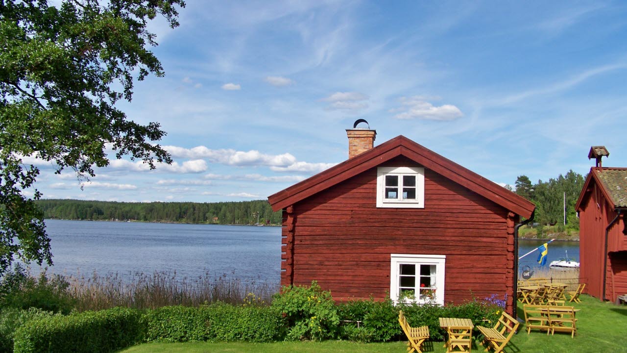 En röd stuga vid en sjö