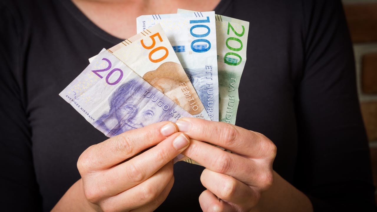 Kvinna håller i pengar.