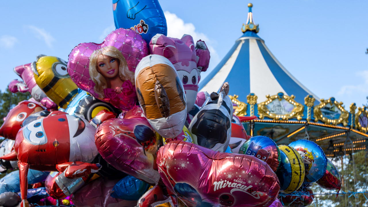 Ballonger och karuseller i flera olika färger mot bakgrund av en himmel