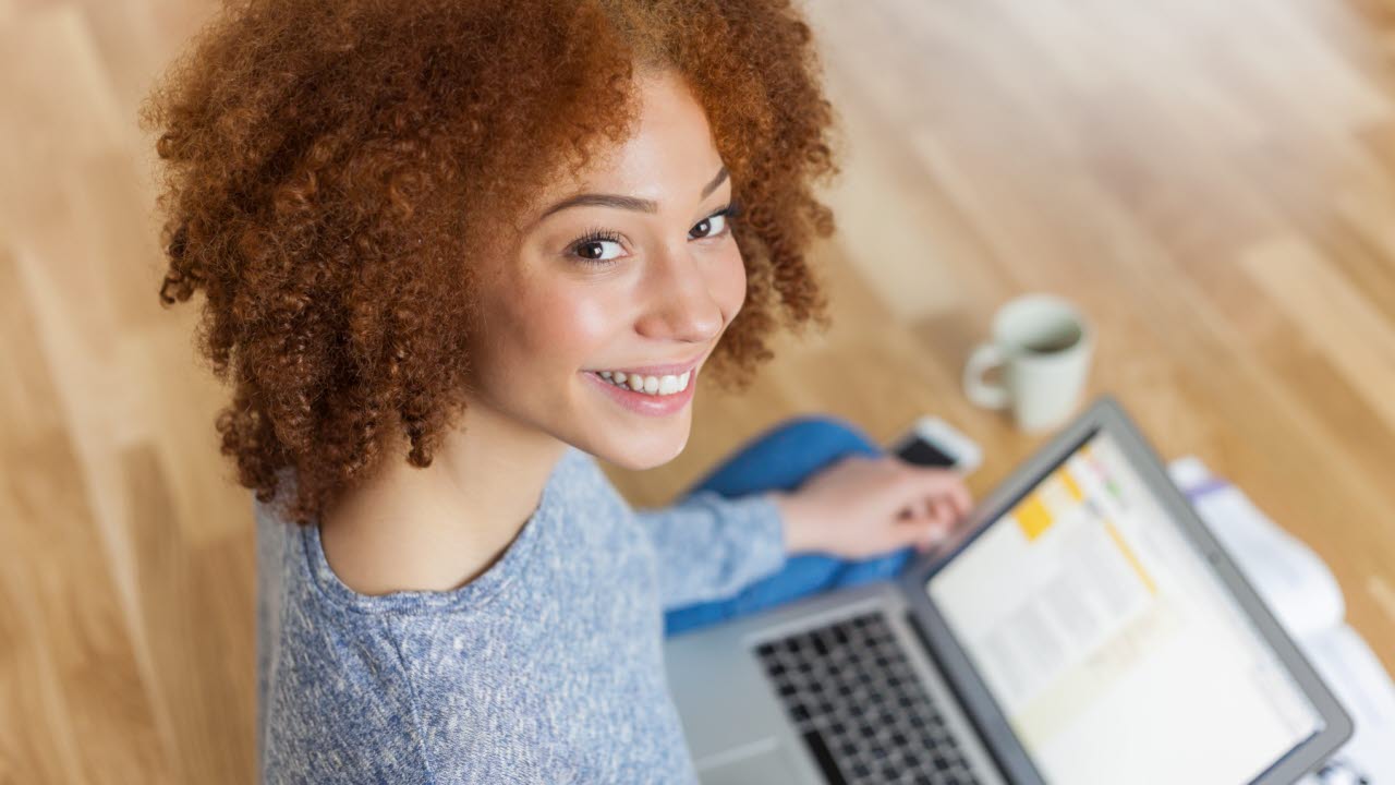 Kvinna med laptop på golvet