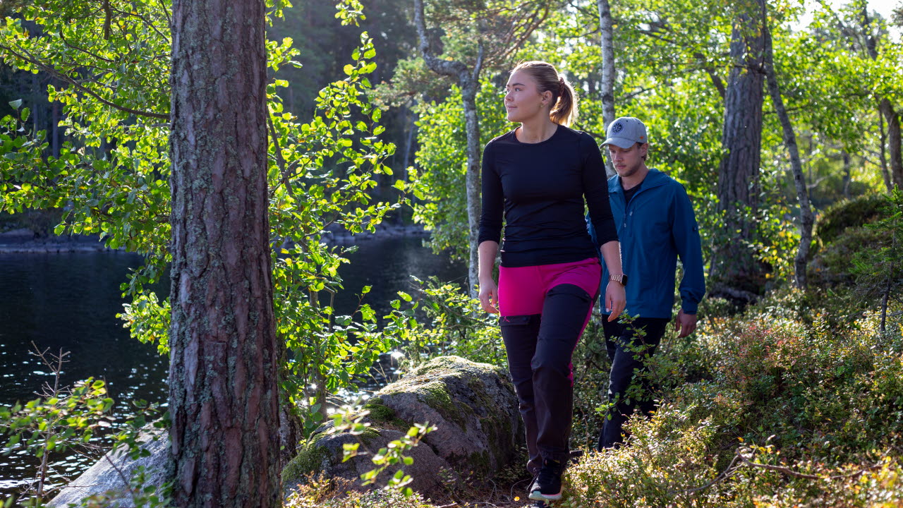 En man och en kvinna vandrar i skogen