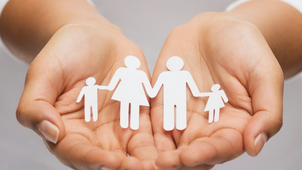 Händer som håller i pappersfamilj