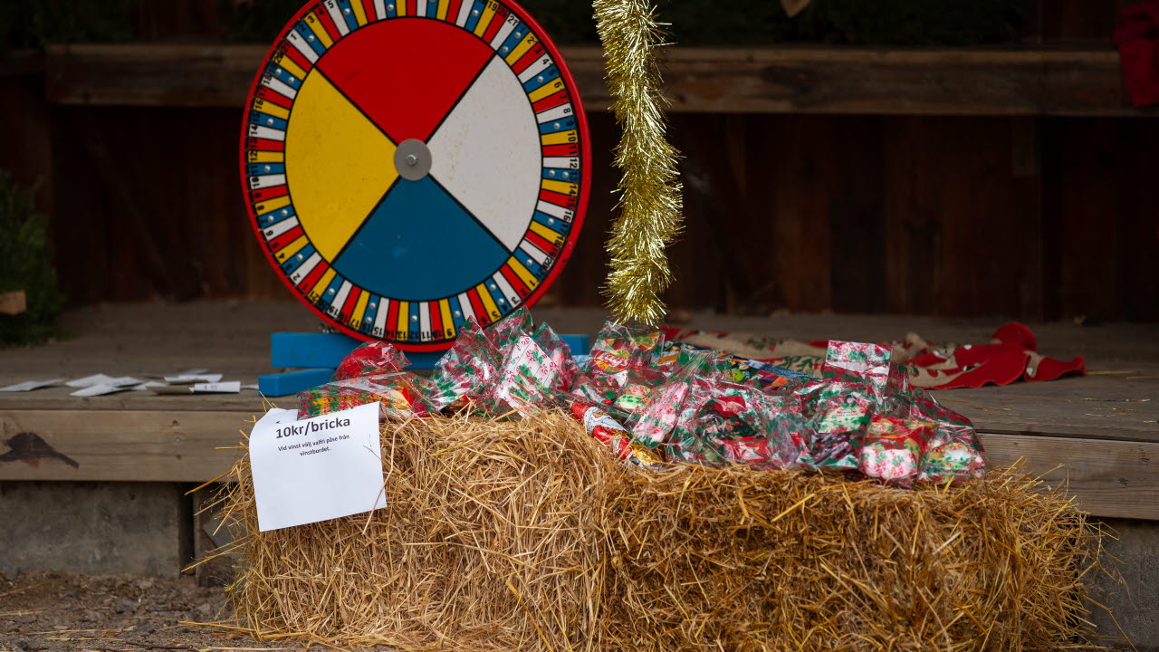 Liten tombola som står vid några halmbalar och inslagna julklappar