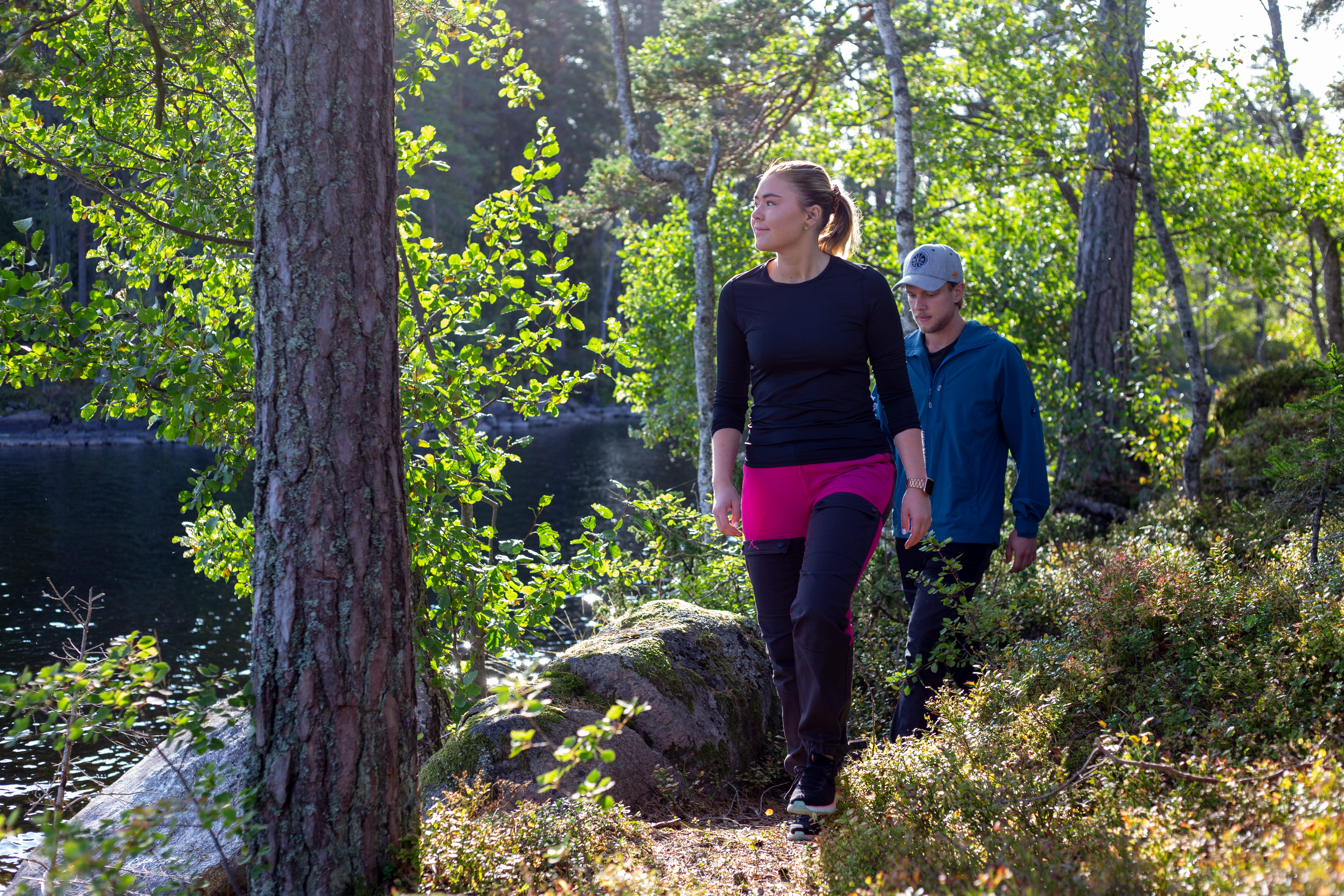 Ett par som vandrar i skogen vid en sjö