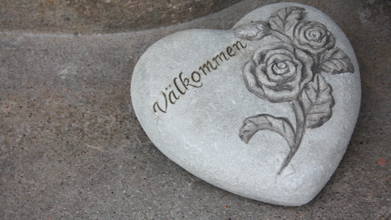 En sten med formen som ett hjärta med texten välkommen på.