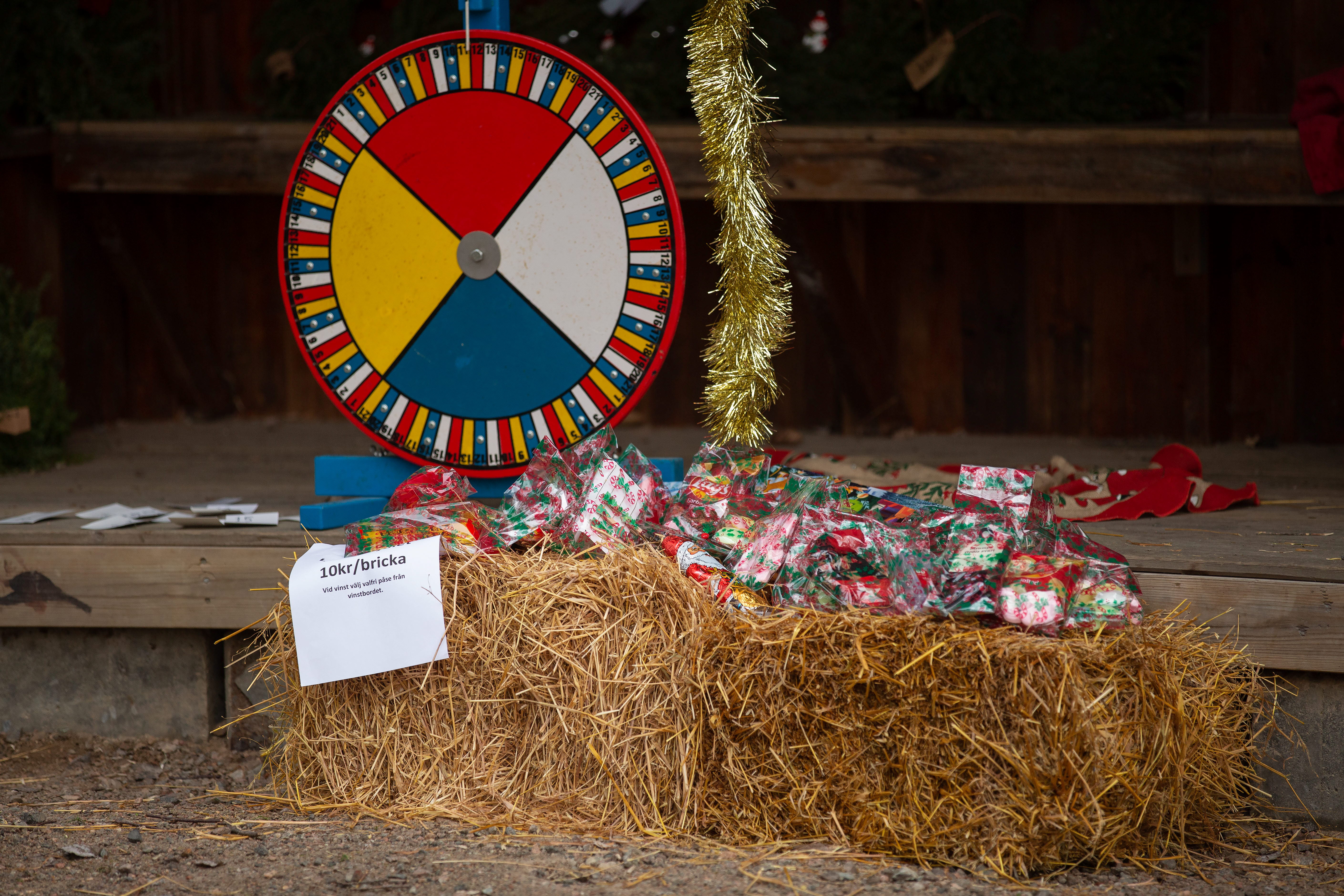 Liten jultombola ståendes vid halmbalar och inslagna julklappar