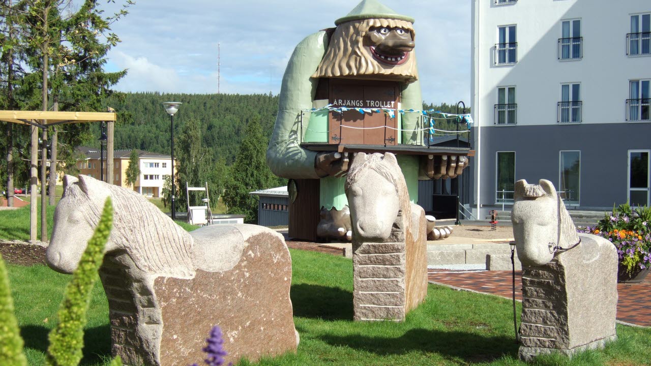 Tre stenhästar med Årjängstrollet i bakgrunden