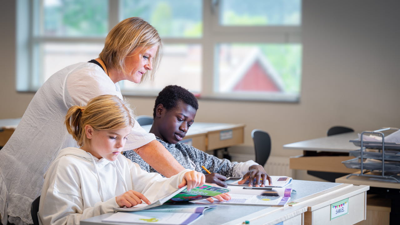 Lärare som stödjer elev under en lektion