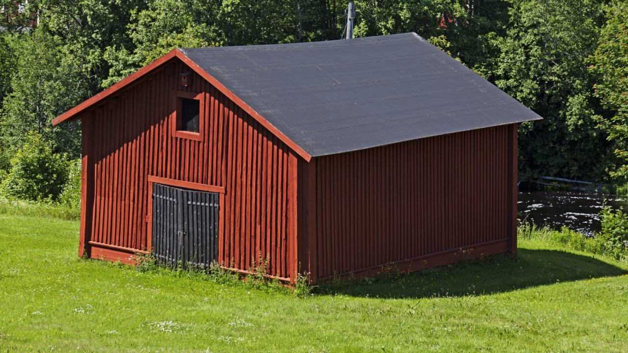 en röd lada med svarta dörrar och tak